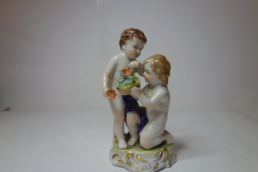 Pair of cherubs with flowers German early 20th C