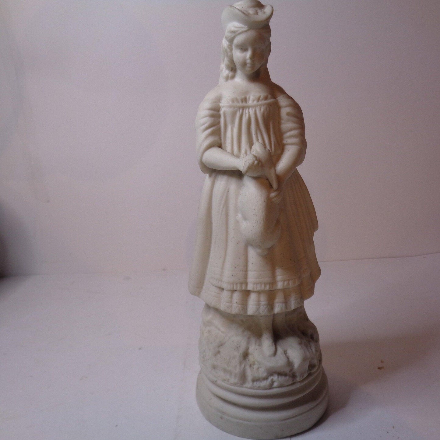 Biscuit porcelain figure of a Victorian girl with rabbit