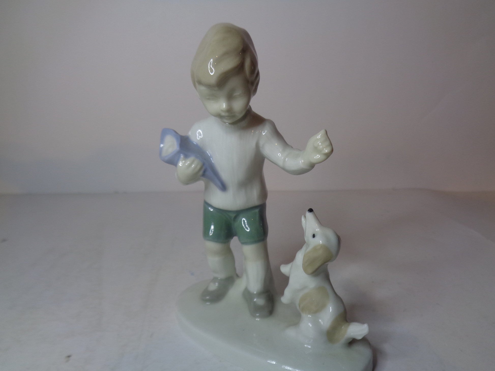 Continental figure of a boy playing with his dog