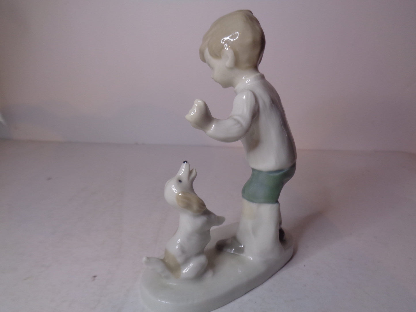 Continental figure of a boy playing with his dog