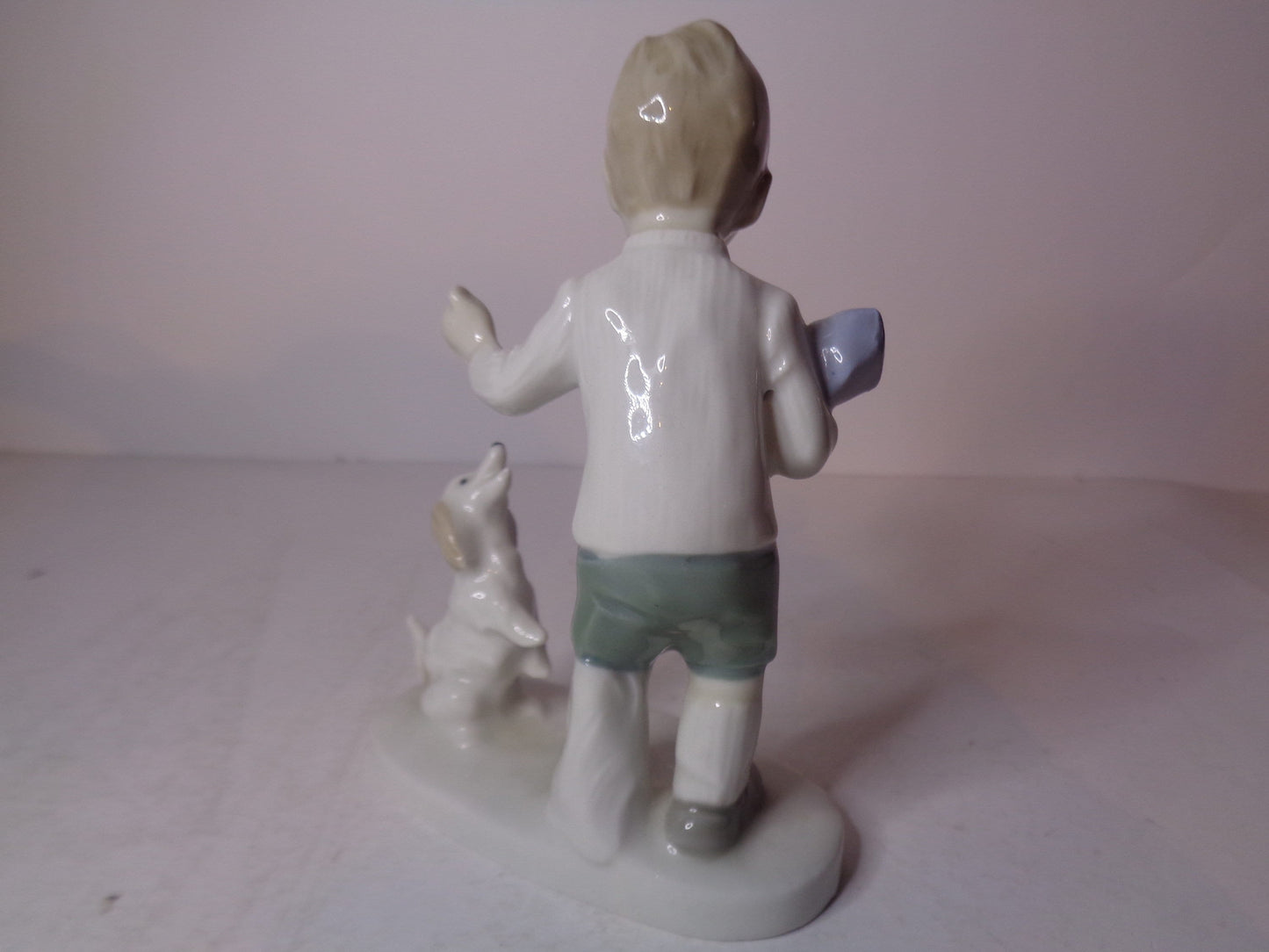 Continental figure of a boy playing with his dog