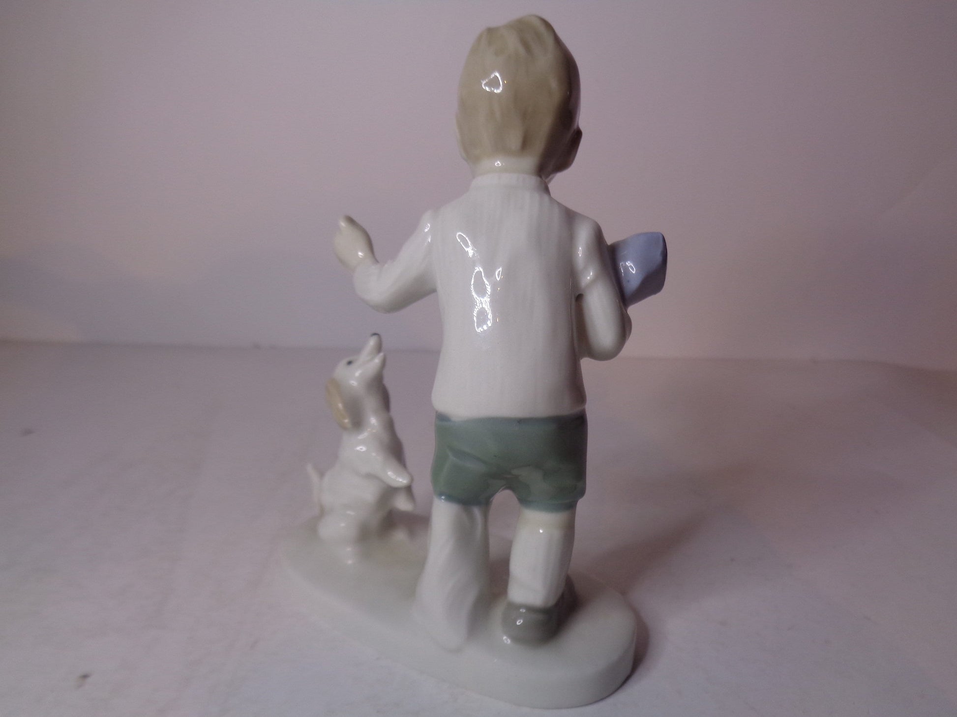 Continental figure of a boy playing with his dog