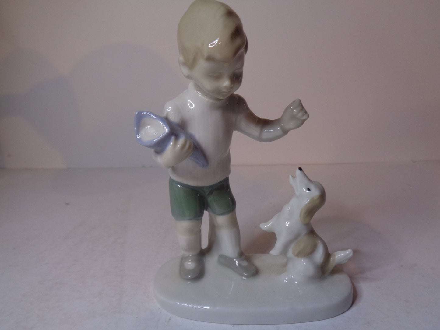 Continental figure of a boy playing with his dog