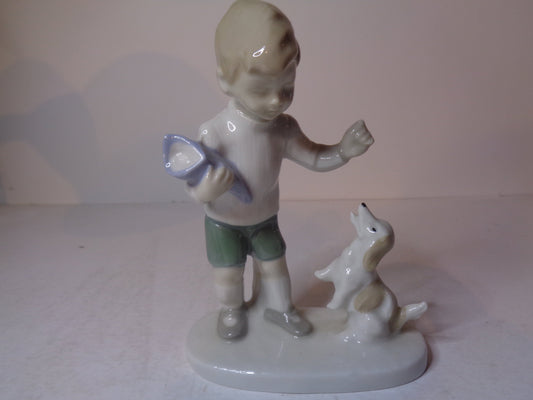 Continental figure of a boy playing with his dog