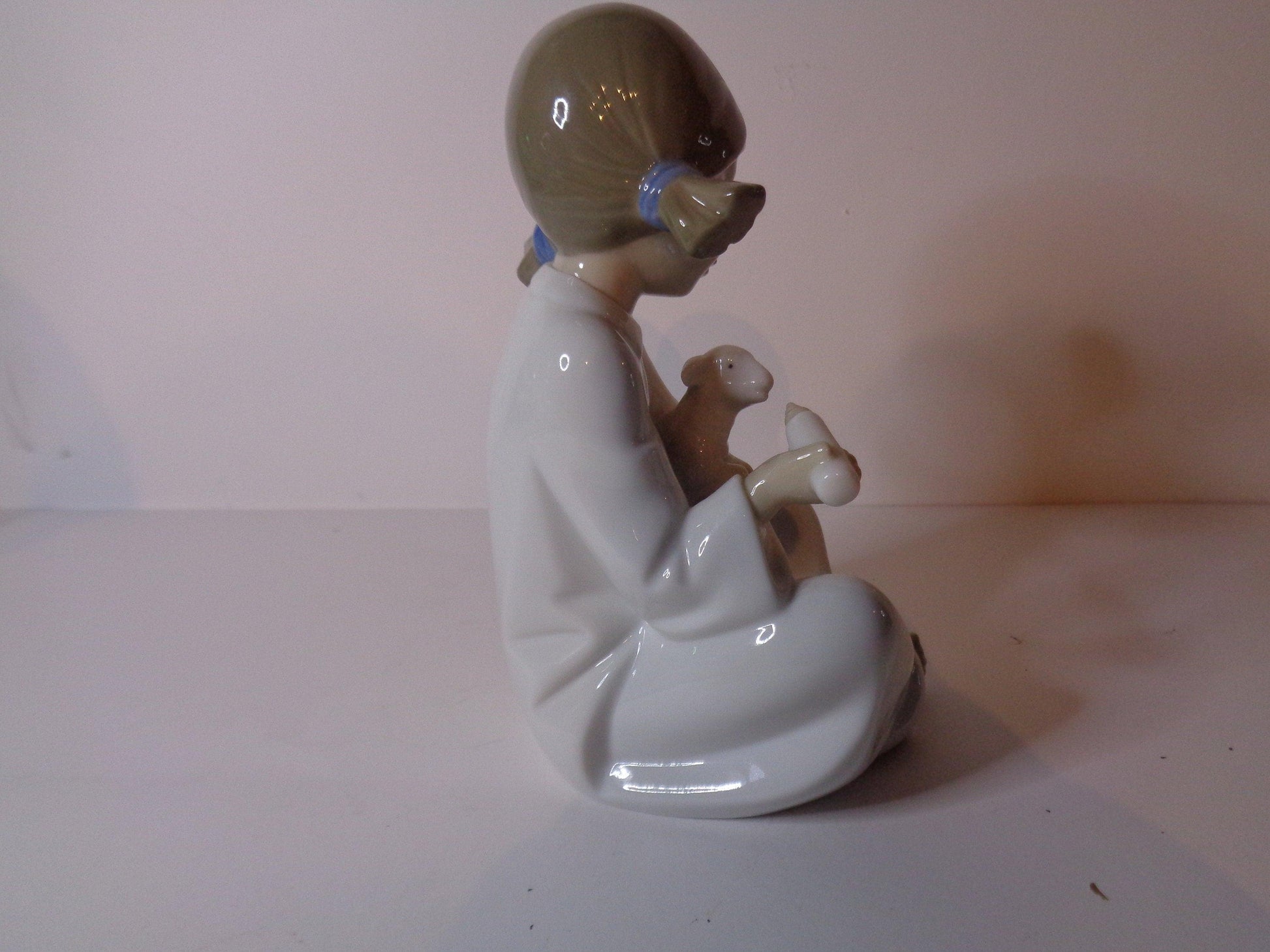 NAO by Lladro Young Shepherdess bottle feeding a lamb